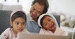 Cute sisters taking a selfie on a laptop with their grandfather and having fun at home. Playful girls and a senior man making funny faces while taking a photo using a computer on the sofa at home. 