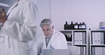 Research scientists writing and discussing chemical formulas on a glass board. Chemical and biological laboratory technicians using modern technology while brainstorming and working in medical lab