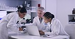 Team of scientists working on laptop in a medical research lab while creating a chemical formula for a vaccine. Diverse researchers brainstorming and discussing solutions to create and discover cure