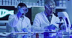 Two laboratory scientists testing phenolphthalein chemical reaction with a petri dish and pipette in ultraviolet lab. Serious doctors wearing protective glasses, experimenting alkaline presence test