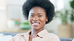 Face portrait of a beautiful African woman with an afro. Cheerful black female laughing and giggling, showing her perfect teeth while sitting at home. Young student or entrepreneur enjoying free time