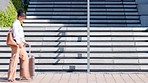 Corporate woman traveling with luggage on a business trip. one modern businesswoman walking with a suitcase arriving at her destination in an urban city for a global conference or overseas convention