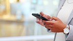 Trendy businesswoman sending a message on her phone. Closeup of corporate worker staying connected after work by typing a message on convenient instant messaging communication app or checking emails