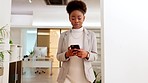 Business woman texting on a phone while walking through a corridor in an office. Focused and ambitious entrepreneur typing a message while scrolling online, browsing apps and networking with clients
