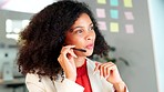 Customer support or call center worker talking to a client and explaining an insurance plan. Fashionable african woman with headphones selling a product or providing a service while working inside