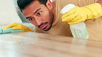 Young man spraying and wiping a table while spring cleaning at home. Closeup of a male sanitizing a surface and doing chores. A cleaner busy with housework for a neat, tidy and hygienic living space