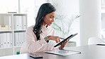 Woman scrolling on the internet looking for new marketing ideas on a digital tablet. One female business woman smiling while searching the internet for creative advertising designs alone at work