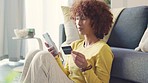 Woman using credit card to make a purchase on her phone while relaxing at home. One happy lady doing online shopping or retail therapy and feeling excited after receiving order confirmation