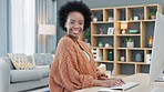 Portrait of an African American woman using a desktop while doing freelance work from a home office. Successful female entrepreneur researching new ideas and marketing strategies for startup company