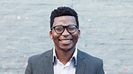 Portrait of a happy male psychologist smiling while standing against a white wall outside in the city alone. The face of one young and cheerful mental health worker working at a hospital or clinic