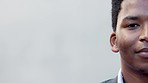 Half face portrait of a man with copy space background. Closeup of a young african male looking calm while staring and blinking isolated on white. Head of a person with dark skin and natural hair