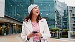 Woman texting on a phone and using social media to chat with friends while commuting to work in the city. One happy and cheerful business woman browsing online and searching the internet downtown