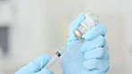 Doctor drawing a vaccine with a syringe at a clinic to vaccinate a patient. A scientist in the COVID 19 medical research and development laboratory holds an injection needle with liquid antibiotics