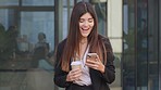 Smiling young female banker using a phone outside in the city. Stylish financial marketer and sales worker on lunch break with coffee and looking happy while browsing online and checking social media