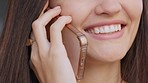 Happy woman talking, chatting and speaking on the phone while smiling and feeling cheerful. Closeup of the hand and mouth of a female with perfect white teeth and healthy oral hygiene routine 