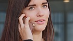 Closeup of the face of a journalist talking on a phone call to find out about a new breaking story while standing at work alone. Zoom of one female news reporter having a conversation with a client