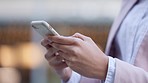 Trendy business woman using her phone outside in an urban city. Closeup of a female texting online or sending an important email on her messaging app while outdoors in a modern town