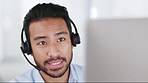 A young male call center agent consulting a client via videocall. A serious customer service or sales employee talking to a buyer. Help desk worker helping and advising a caller