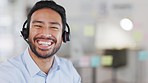 Face of a male support engineer working at a call center with copy space. Young technical agent with a headset happy to be of service to remote clients helping them with software troubleshoot queries