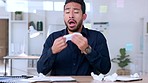 Sick business man suffering from flu and allergies while sneezing and blowing his nose at his messy desk. Unwell entrepreneur sitting in an office and feeling terrible from cold while doing paperwork