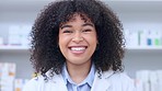 Pharmacist and healthcare worker working in a drugstore and delivering friendly and excellent service. Portrait of African afro woman smiling in front of shelves waiting to assist and give advice 
