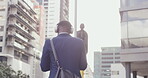 Headphones, music listening businessman walking in modern corporate business area. Young African American male enjoying motivational audio in urban city downtown after successful day at work.