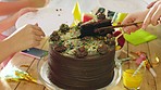 Colorful, sweet and festive chocolate cake at a kids party cut into slices during a vibrant summer holiday. Celebrating a special birthday occasion by enjoying delicious baked snacks, food and drinks
