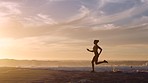 Silhouette of active, healthy and fit woman running on a beach at sunset in slow motion. Young focused and determined female exercising and training outside near the ocean at dawn dusk or sunrise