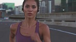 Fitness, exercise and running woman training in the city street or road with earphones. Healthy young runner or athlete practice sport cardio workout routine outdoor in the urban road in a town