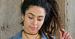 Closeup of a trendy, edgy and flirty woman with braided hair or dreadlocks, smiling with and happy expression. Headshot, face and portrait of funky, stylish and boho rocker against wood background