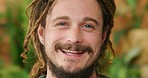 Happy, smiling and carefree hippie man standing outside against a organic nature background. Closeup face of healthy guy with dreadlocks laughing and enjoying life with positive attitude while high