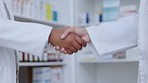 Handshake, partnership and FDA drug approval by pharmacists and healthcare workers in a pharmacy. Chemists shaking hands to welcome, say thank you and showing trust for b2b health deal or contract