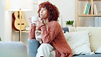 Calm, drinking and thinking African American woman daydreaming enjoying coffee, tea or cosy beverage while relaxing at home. Casual, leisure and alone female in relaxed environment taking a break.