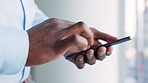 Chatting, texting or typing hands of a business man on a phone in a modern office. Closeup of an African American businessman browsing social media, online or sms message or emails while at work
