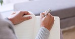 Woman hands writing in notebook, journal or diary with a pen and sitting on sofa while relaxing at home on the weekend. Female freelance writer relax and write a rough draft or sample in a book