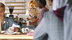 Cafe, coffee shop and barista serving a customer while standing behind a bar counter. Friendly service of a female worker, staff or waiter in apron while helping people or taking order in coffeehouse