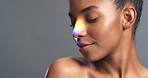 Natural face, beauty and rainbow light or ray on happy and proud woman against a grey background. Skincare, lgbtq and gender pride or expression of a strong black lesbian female feeling sensual