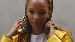 Music, headphones and face with a black woman streaming or listen to an online subscription service against a gray background. Braids, hair and radio with a young female listening to audio closeup