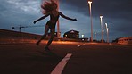 Freedom, dance and woman dancing in the road on a highway with the street lights. Flexible, fit and young ballet girl moving to a routine with energy at night time in the city during summer.