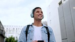 Happy, headphones and phone of a man in the city walking, listening and streaming music on the internet outside. Male in happiness with smile for 5G connection on mobile smartphone, podcast in a town