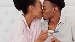 African couple reading pregnancy test, excited about a baby in home and smile for pregnant success. Happy, love and kiss man an woman holding results from fertility check and giving kiss in house