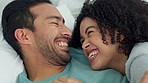 Happy, love and laugh with a couple laughing at a funny joke with a smile and bonding together in the bedroom of their home. Laughing, romance and bed with a young man and woman enjoying time off