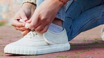 Woman tie a fashion shoe lace on the ground or floor outdoor while in the city. Casual female stylish shoes in a street or road with fancy, fashionable and cool footwear while walking in town