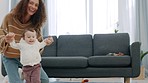 Baby, walking and mom help, support and teaching her kid a life skill on home living room floor. Mother's love, trust and family woman with boy learning how to walk during child development or growth