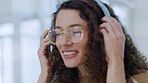 Face, music and headphones with a beautiful woman in glasses streaming an online subscription service in her home. Relax, smile and carefree with a cute girl sitting in a house alone during the day