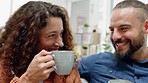 Happy couple, love and morning coffee while sharing a toast and celebrating free time on a cozy sofa over the weekend at home. Happy man and woman in healthy and loving marriage relationship together