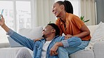 Happy couple, selfie video and phone with smile on sofa in the living room relaxing at home in happiness. Black man and woman in relationship smiling together on couch in social media on smartphone