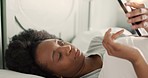 Bed, relax and woman texting on a phone, carefree and content in her bedroom. African American female reading news, social media and chatting online friends while lying down and resting in her home