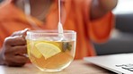 Calm woman with green tea with lemon for health, wellness and relax while working, listening to music on earphones in living room or home. Healthy lifestyle black woman with herbal drink or beverage