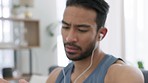 Fitness man reading time on watch with music after workout training in house, listening to podcast and check clock for heart health after exercise in home. Asian athlete on technology for sport